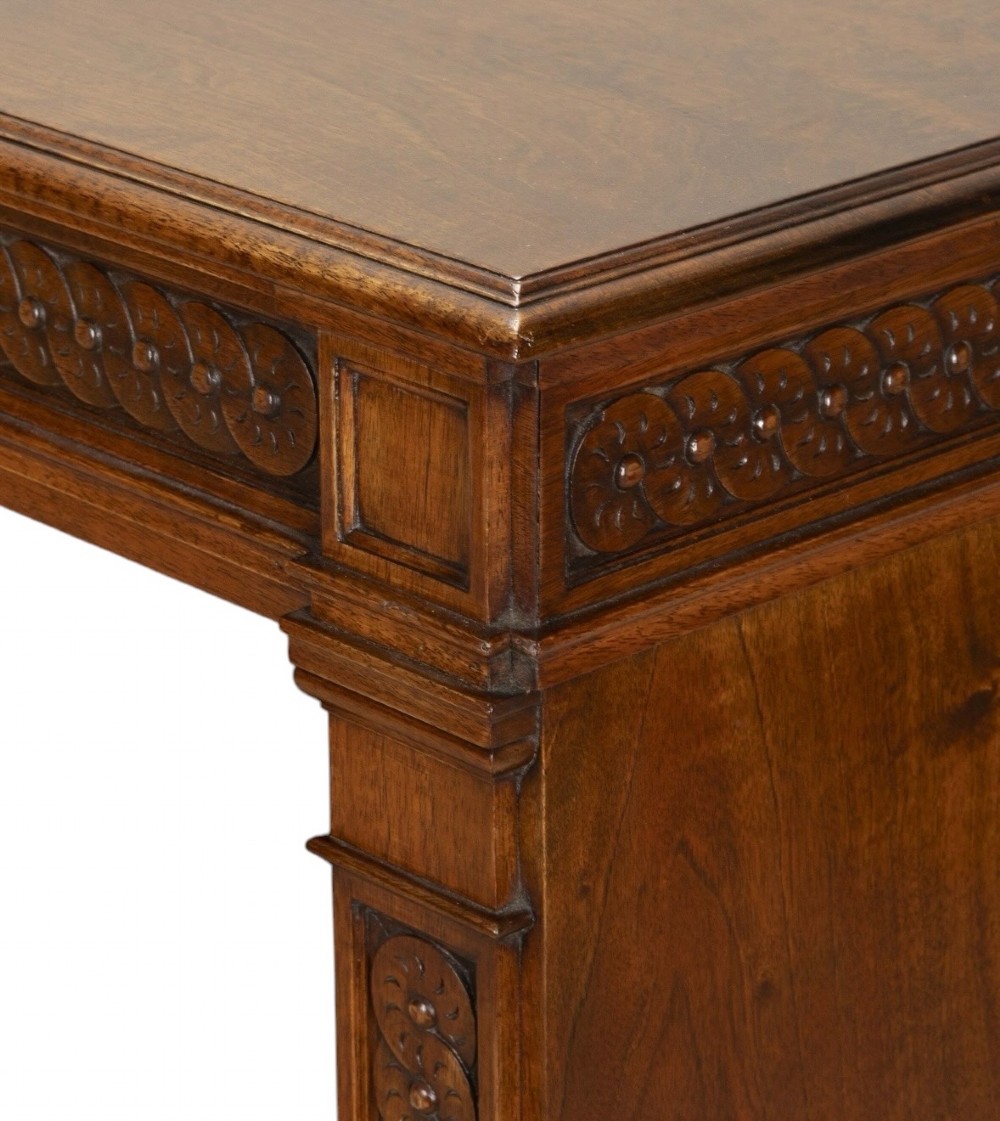 A late nineteenth-century Victorian walnut open bookcase featuring three horizontal shelves, carved frieze detail, and fluted side pilasters on a solid plinth base. View IX