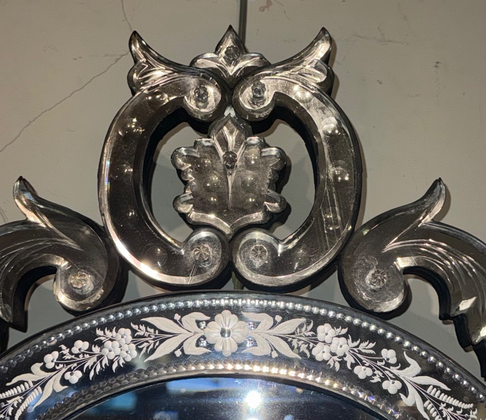 An ornate Venetian wall mirror featuring hand-etched floral glass borders, a decorative crest pediment, and a scalloped inner frame. View III