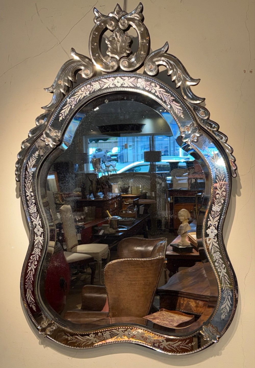 An ornate Venetian wall mirror featuring hand-etched floral glass borders, a decorative crest pediment, and a scalloped inner frame. View V