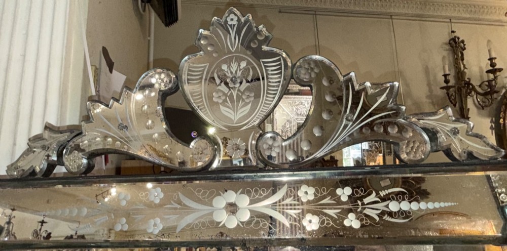 A large rectangular Venetian wall mirror featuring etched floral border panels, bevelled glass edges, and a prominent scrolling glass crest. View IV