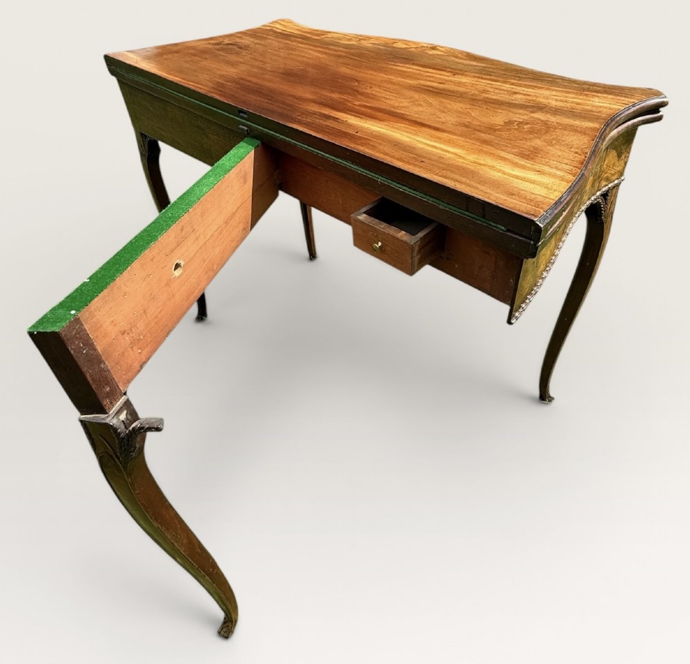 An antique warm brown mahogany card table with a serpentine front, carved cabriole legs, and a hinged fold-over top. View VI