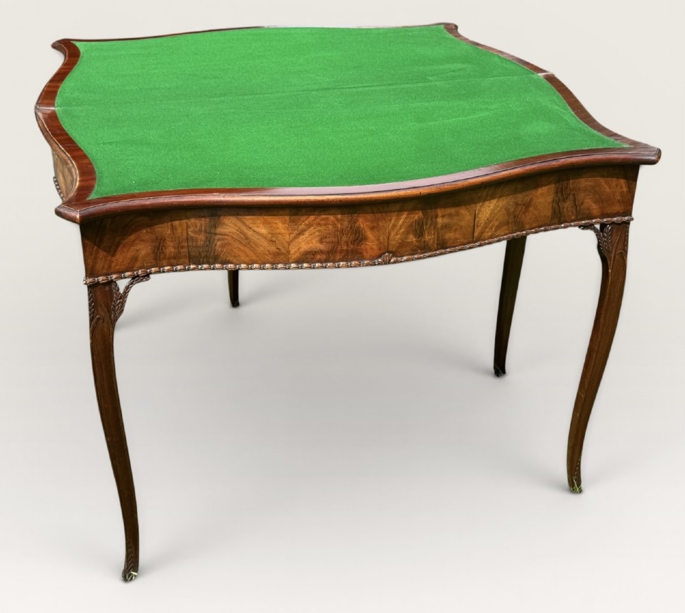 An antique warm brown mahogany card table with a serpentine front, carved cabriole legs, and a hinged fold-over top. View IX