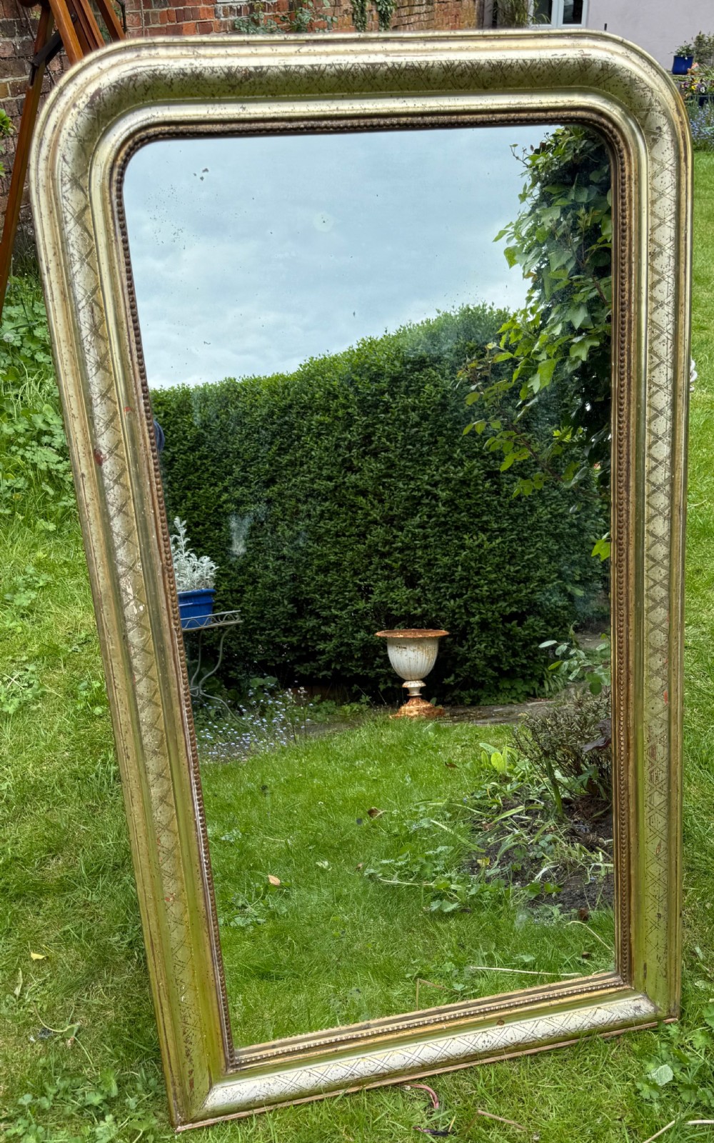 A large rectangular Louis Philippe mirror featuring rounded upper corners, a silver gilt frame with etched cross-hatch patterning, and a beaded inner border. View III