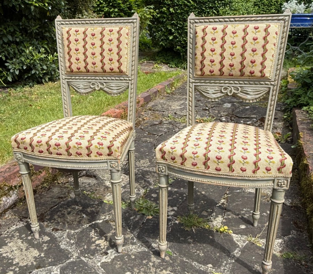 A pair of grey-painted Louis XVI style side chairs with fluted legs and floral needlepoint fabric upholstery. View VI