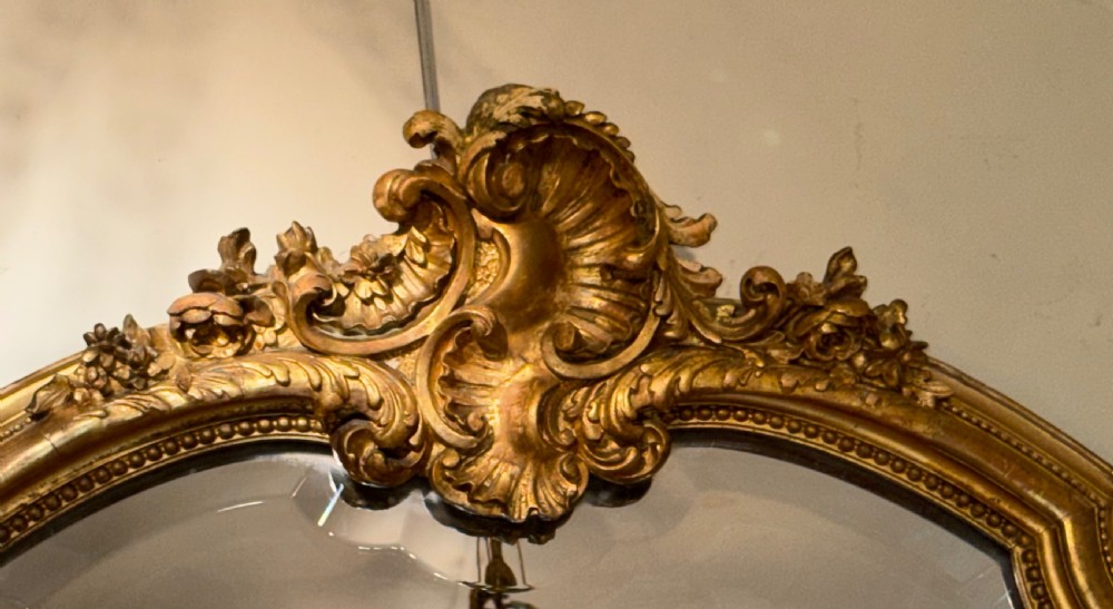 A large 19th-century arched giltwood overmantel mirror featuring a carved shell motif crest and beaded inner border. View II