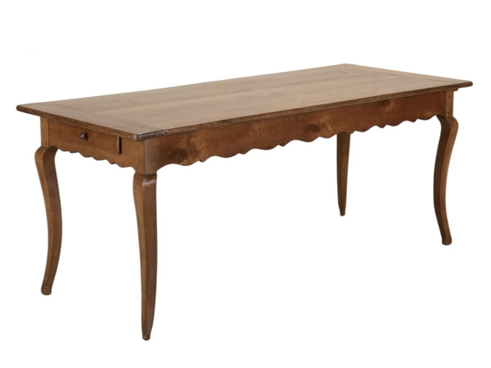 A nineteenth-century French cherry wood farm table featuring cabriole legs, a scalloped apron, and a single end drawer.