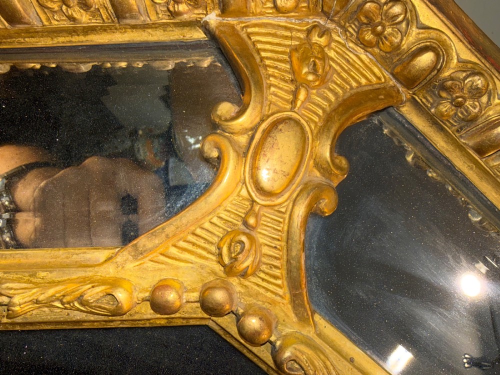 A 19th-century octagonal giltwood cushion wall mirror featuring ornate cresting, egg-and-dart moulding, and angled perimeter mirror plates. View II