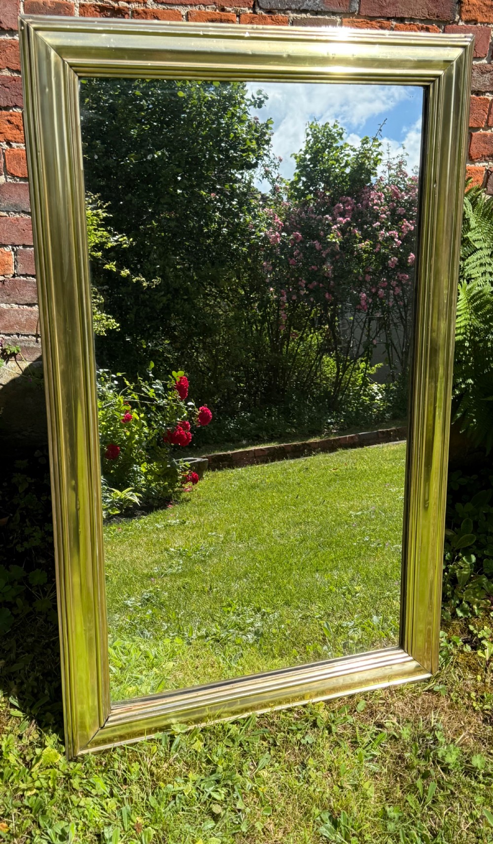 A large rectangular wall mirror featuring a polished brass frame with a wide moulded profile. View VI