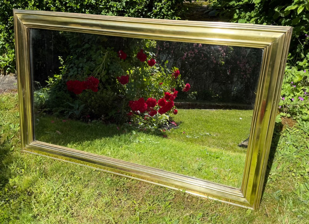 A large rectangular wall mirror featuring a polished brass frame with a wide moulded profile. View VII