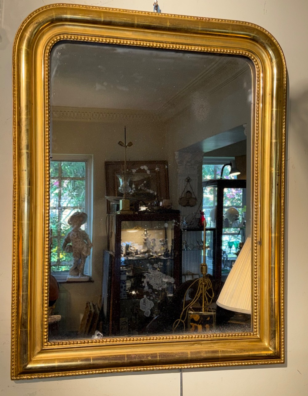 A rectangular French Louis Philippe giltwood wall mirror featuring rounded upper corners and a beaded inner moulding. View V