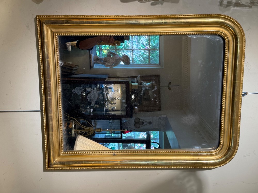 A rectangular French Louis Philippe giltwood wall mirror featuring rounded upper corners and a beaded inner moulding. View VI