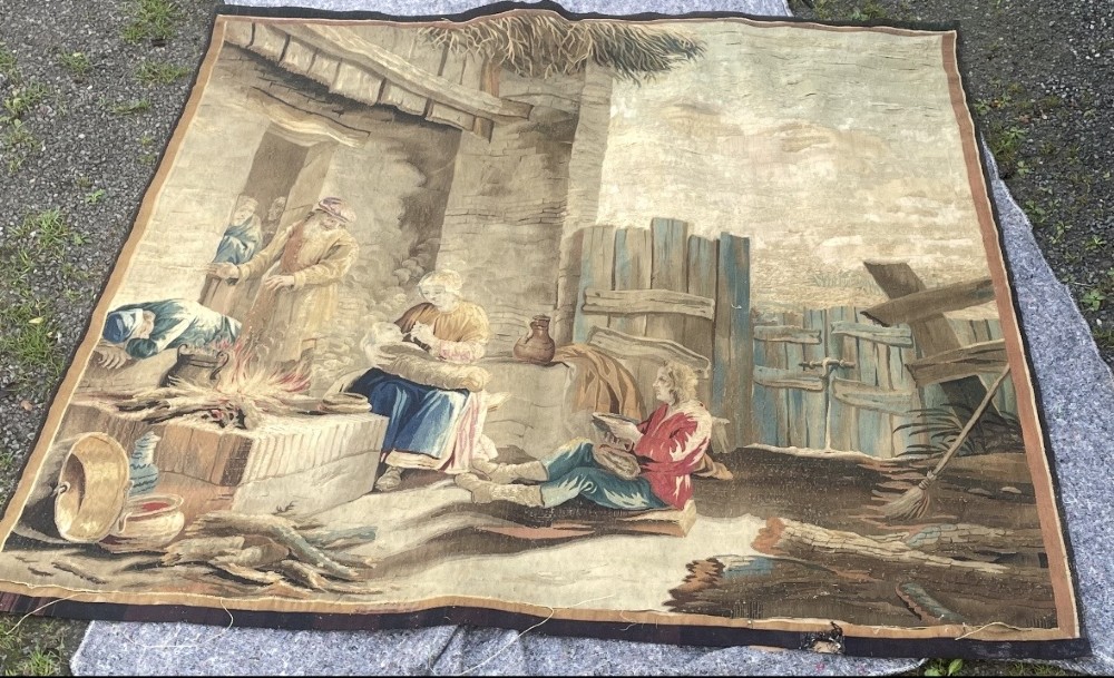 A late seventeenth-century Brussels woven wool and silk tapestry depicting a rustic genre scene with figures near a stone hearth in neutral brown and beige tones. View II