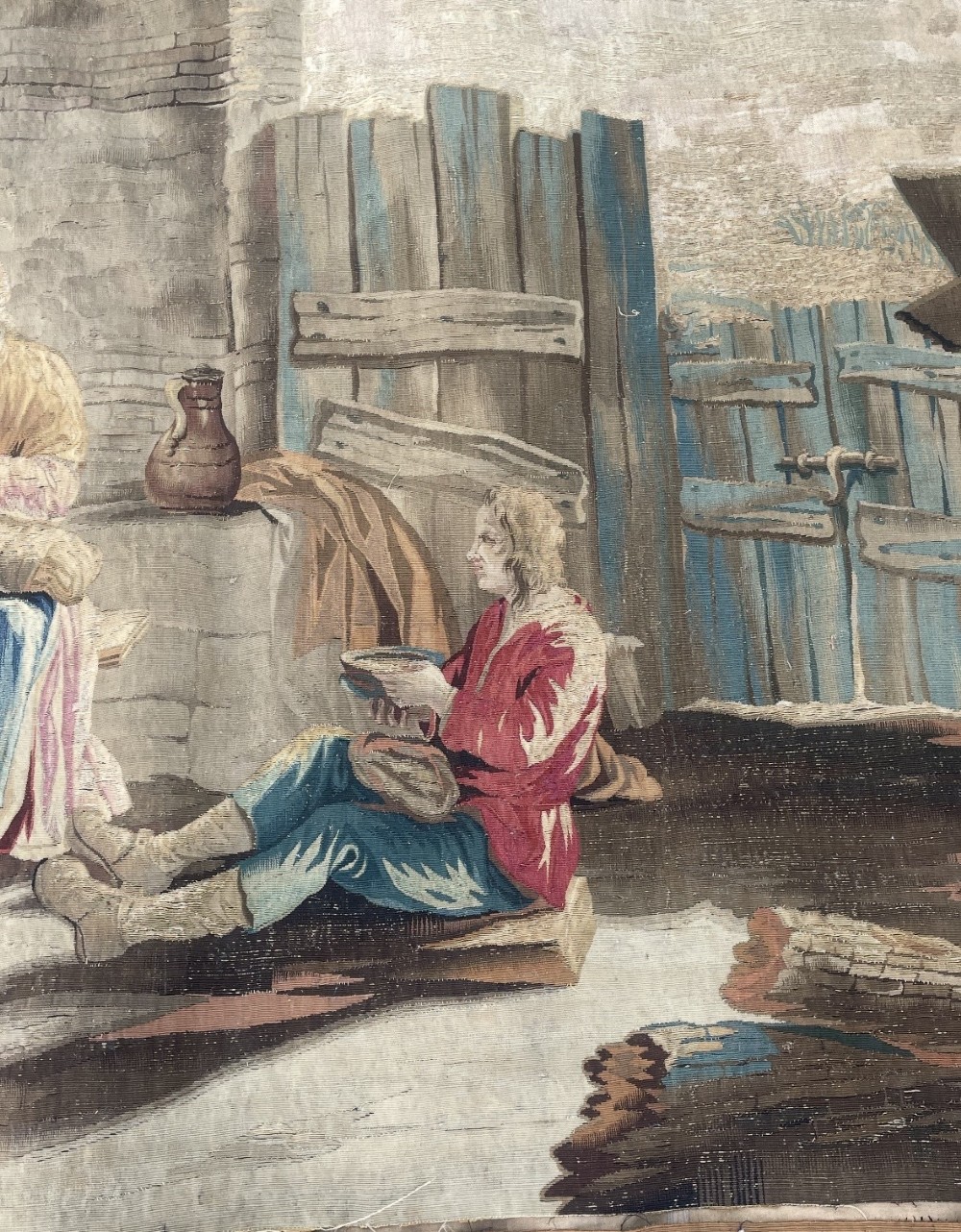 A late seventeenth-century Brussels woven wool and silk tapestry depicting a rustic genre scene with figures near a stone hearth in neutral brown and beige tones. View III