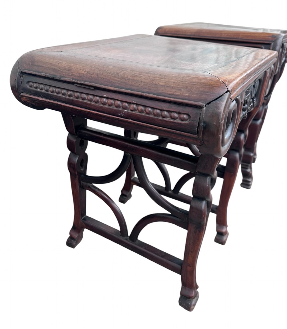 A pair of 19th-century carved dark hardwood side tables with scrolled tops and pierced floral aprons. View II