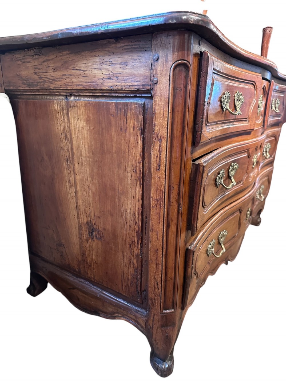 An 18th-century French Provincial cherry wood commode featuring three drawer tiers, ornate brass drop handles, moulded panel drawer fronts, and short cabriole feet. View II