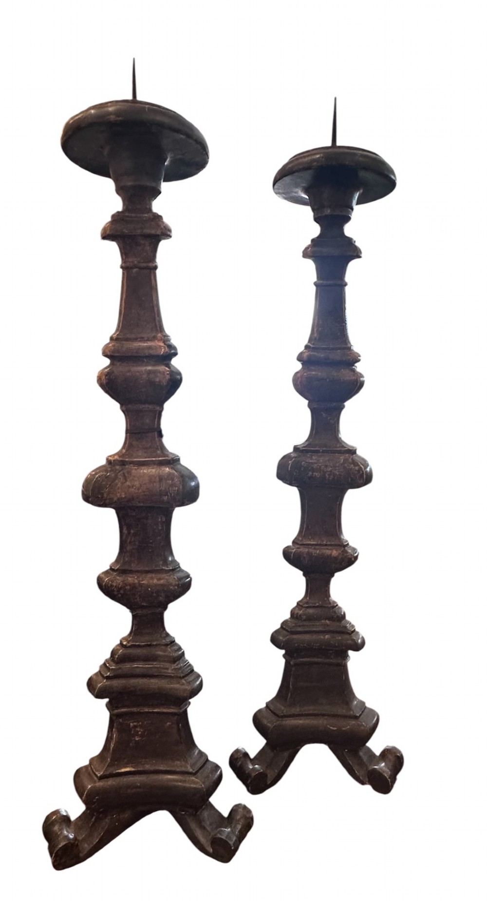 A pair of 19th-century French carved wooden pricket candlesticks featuring baluster turnings and tarnished silver leaf finishing.