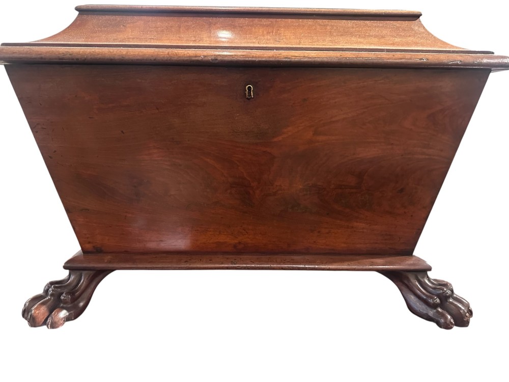 An 18th-century Georgian mahogany sarcophagus-form cellarette featuring a hinged stepped lid, brass escutcheon, and carved paw feet.