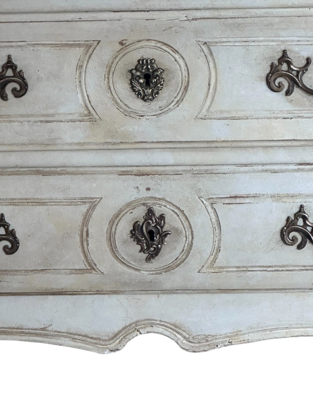 An 18th-century French Provencal style painted commode featuring a dark marble top, two wide drawers with ornate metal handles, and slender cabriole legs. View II