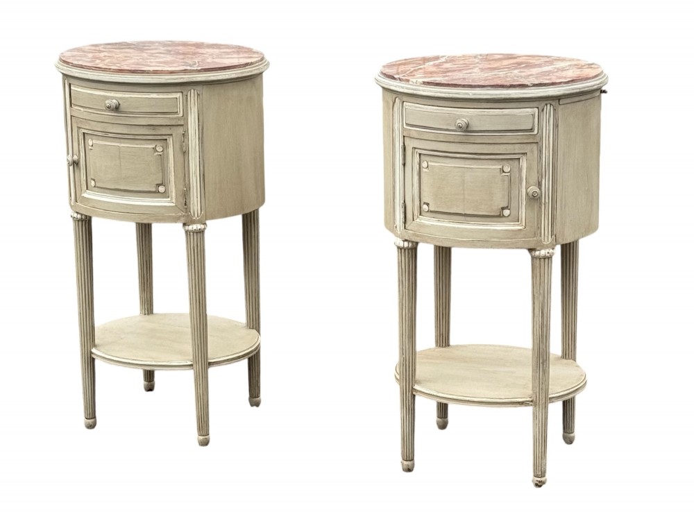 A pair of round 19th-century French painted bedside tables with pink marble tops, single drawers, cupboards, and fluted legs with a lower shelf. View II