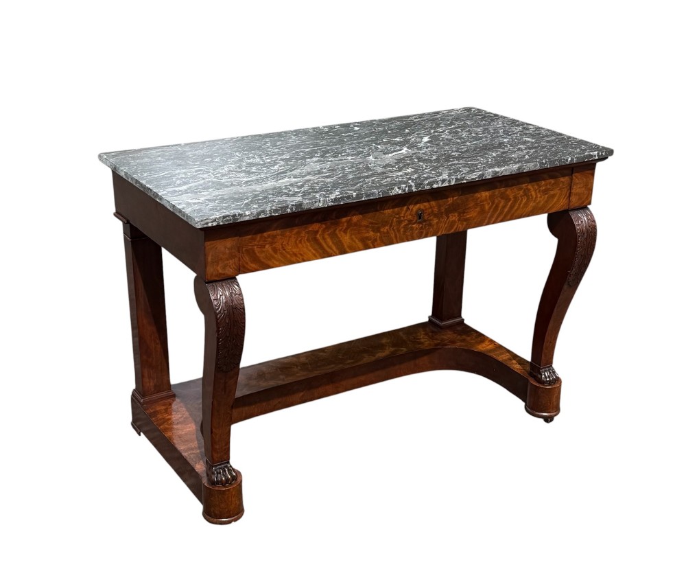 A 19th-century French Louis Philippe mahogany console table featuring a grey marble top, single frieze drawer, curved scroll front legs with acanthus carvings, and an incurved plinth base.
