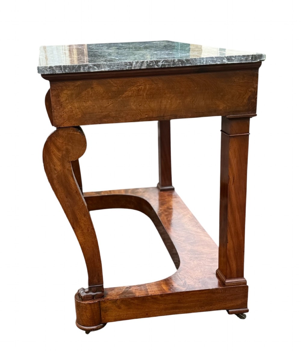 A 19th-century French Louis Philippe mahogany console table featuring a grey marble top, single frieze drawer, curved scroll front legs with acanthus carvings, and an incurved plinth base. View II