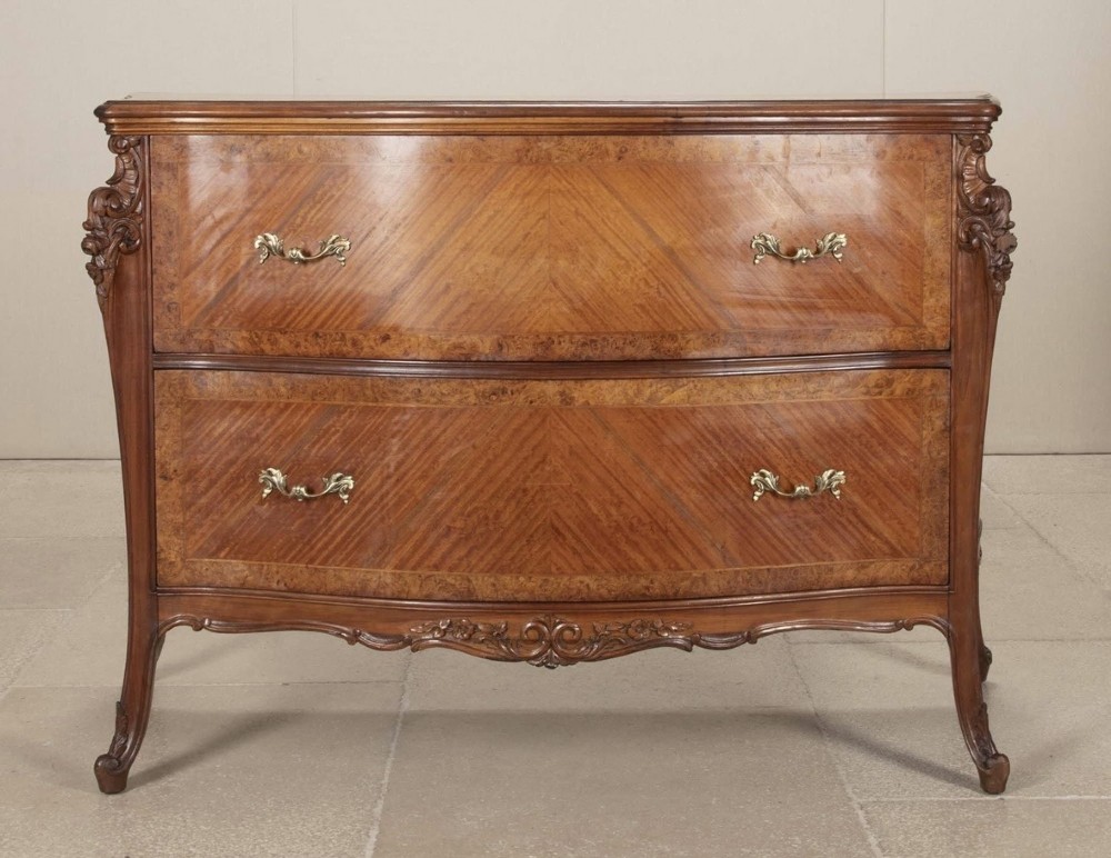 A 19th-century Italian commode featuring two drawers with chevron-patterned satinwood veneers, burr walnut borders, and ornate brass handles.