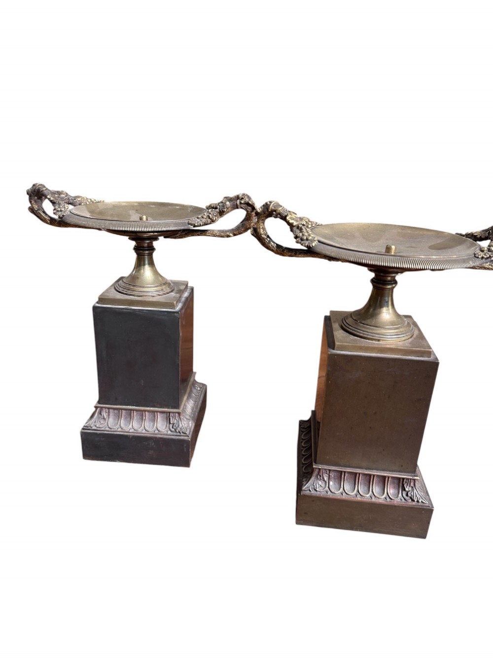 A pair of 19th-century French Empire style ormolu and bronze tazzas featuring grapevine handles and dark rectangular plinths. View II