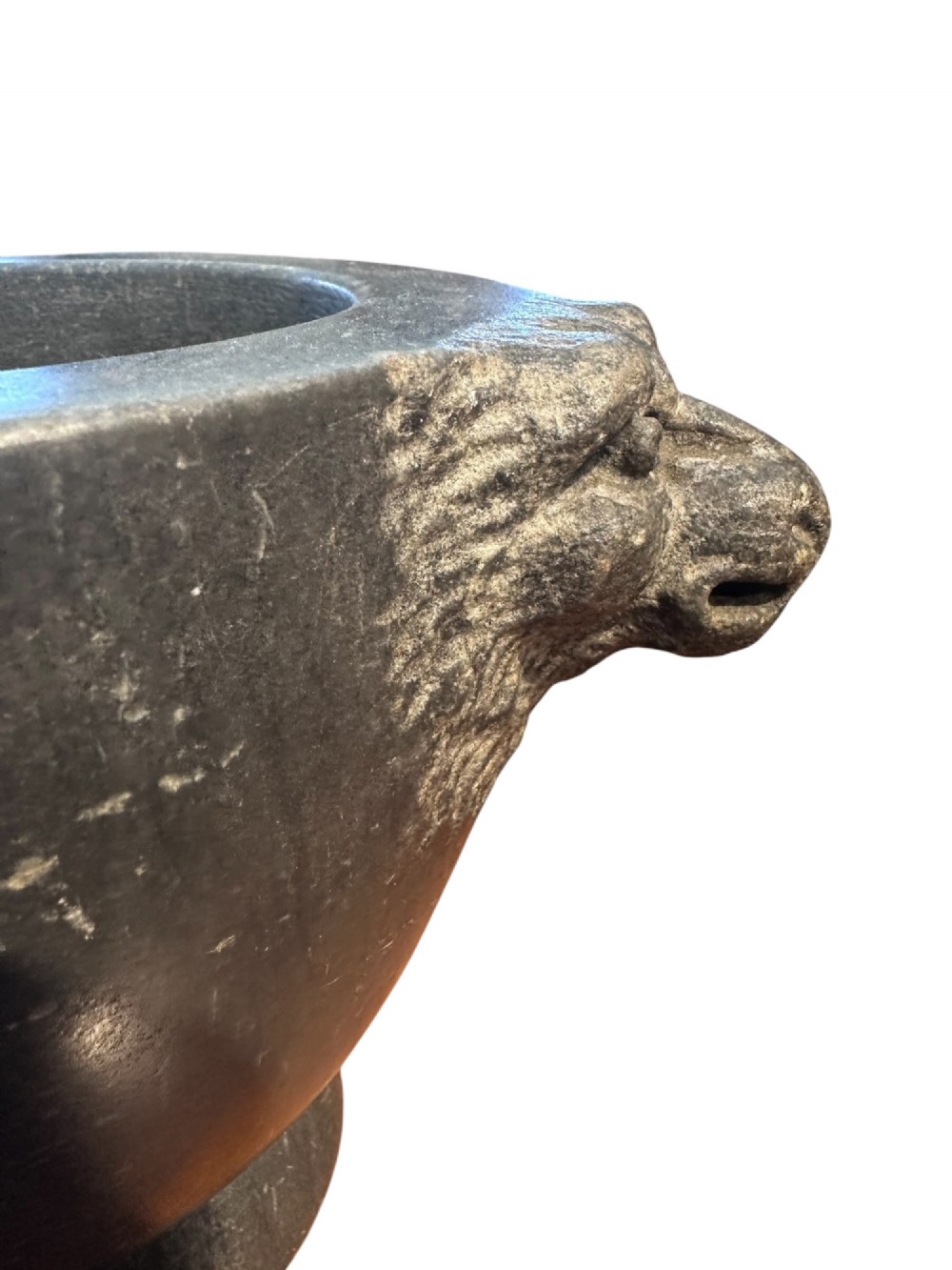 An 18th century dark charcoal basalt stone mortar featuring carved lion head handles and a rounded pedestal foot. View III