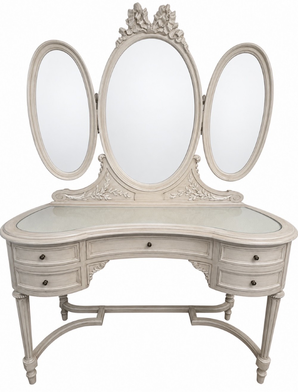 An off-white painted Edwardian kidney-shaped dressing table featuring five drawers, fluted legs, a glass inset top, and an attached triple oval mirror decorated with carved ribbon cresting.