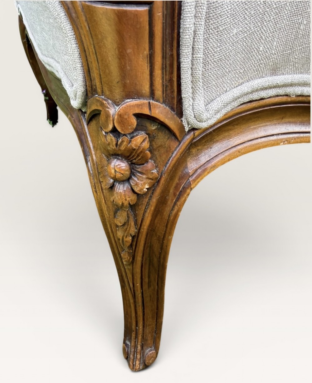 A pair of French Louis XV style Bergere armchairs featuring carved walnut wood frames and neutral light cream linen upholstery. View VII