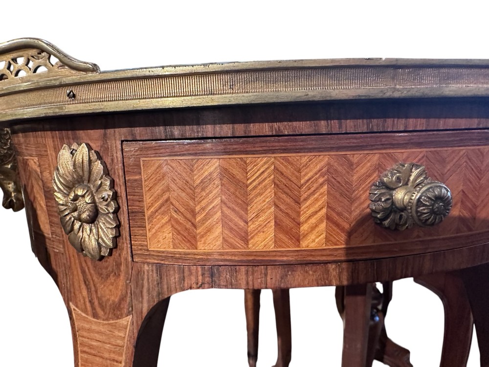A pair of oval kingwood bedside tables featuring brass gallery rails, glass tops, lower undertier shelves, and slender cabriole legs with metal mounts. View IV