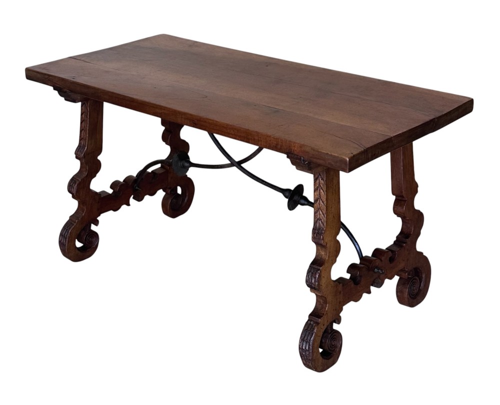 A nineteenth-century Spanish walnut dining table featuring carved lyre-shaped trestle legs and curved wrought iron stretchers.
