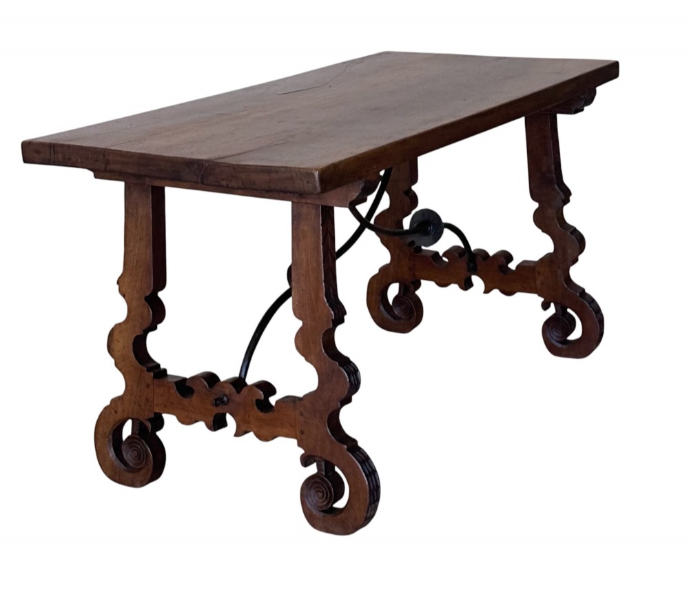 A nineteenth-century Spanish walnut dining table featuring carved lyre-shaped trestle legs and curved wrought iron stretchers. View II