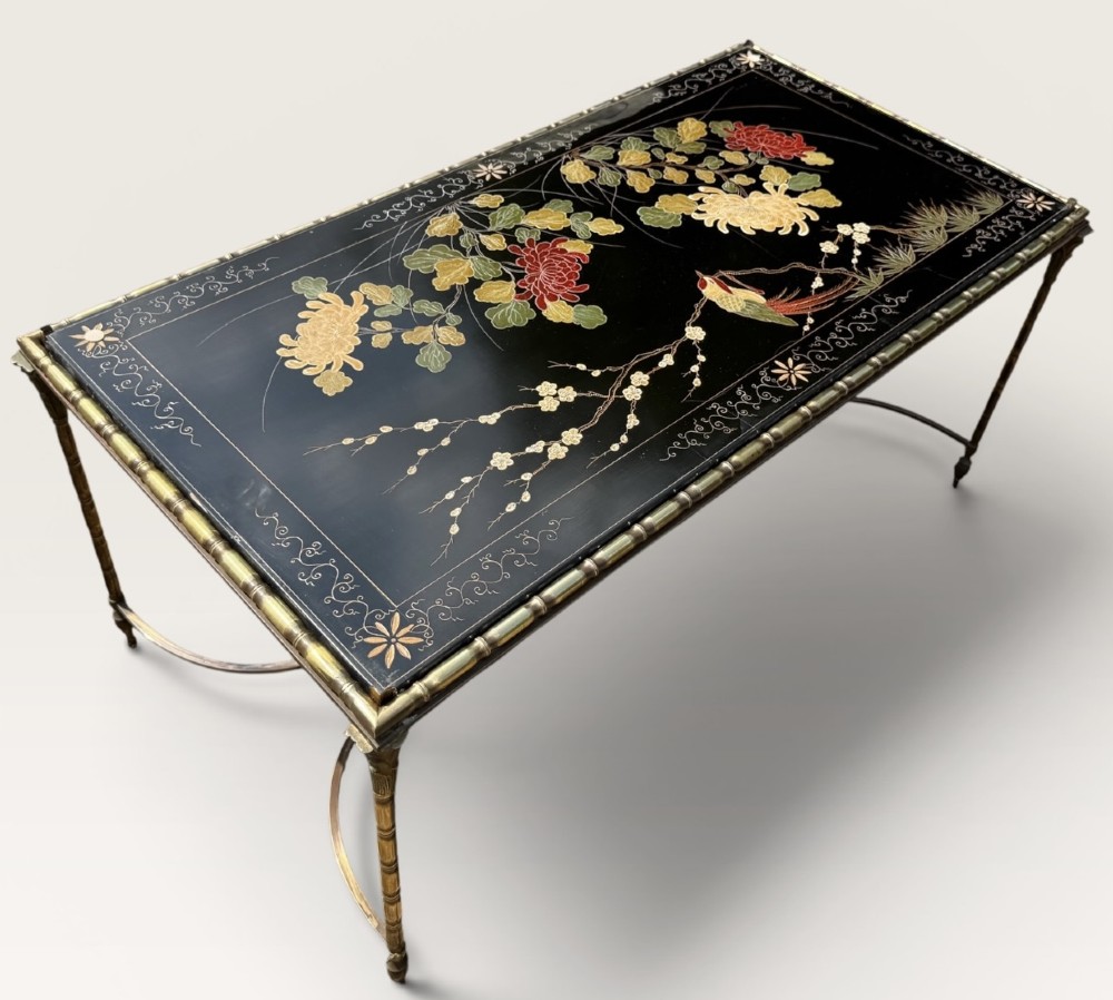 A rectangular mid-century low table featuring a faux-bamboo brass frame, X-form stretchers, and a black lacquered top decorated with colourful Chinoiserie floral patterns. View II