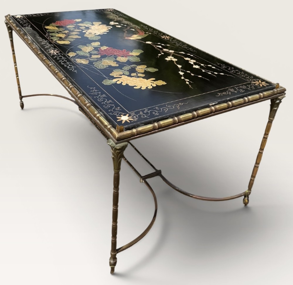 A rectangular mid-century low table featuring a faux-bamboo brass frame, X-form stretchers, and a black lacquered top decorated with colourful Chinoiserie floral patterns. View IV