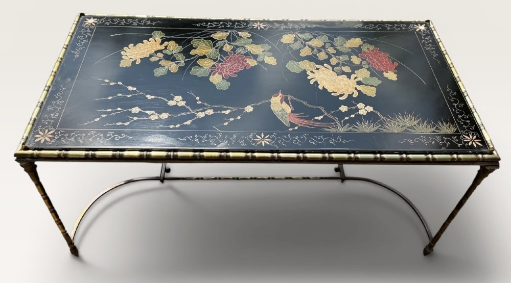 A rectangular mid-century low table featuring a faux-bamboo brass frame, X-form stretchers, and a black lacquered top decorated with colourful Chinoiserie floral patterns. View VI