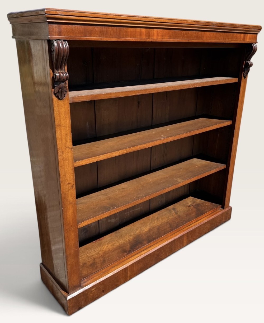 A 19th-century Victorian open walnut bookcase featuring four tiers, decorative carved corbels beneath a moulded top cornice, and a solid plinth base. View III