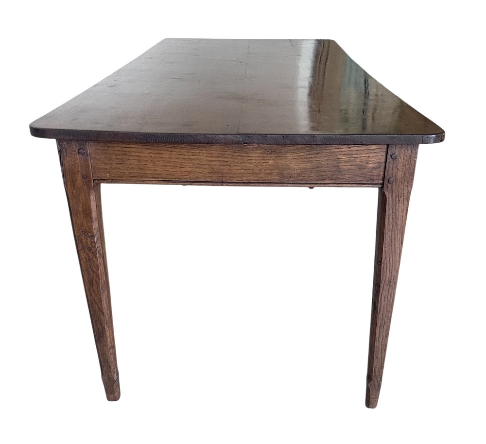A large nineteenth-century French oak farmhouse table featuring a rectangular plank top, a frieze drawer with a wooden knob, and four tapered square legs. View III