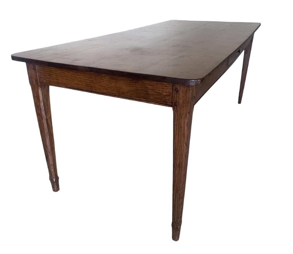 A large nineteenth-century French oak farmhouse table featuring a rectangular plank top, a frieze drawer with a wooden knob, and four tapered square legs. View IV