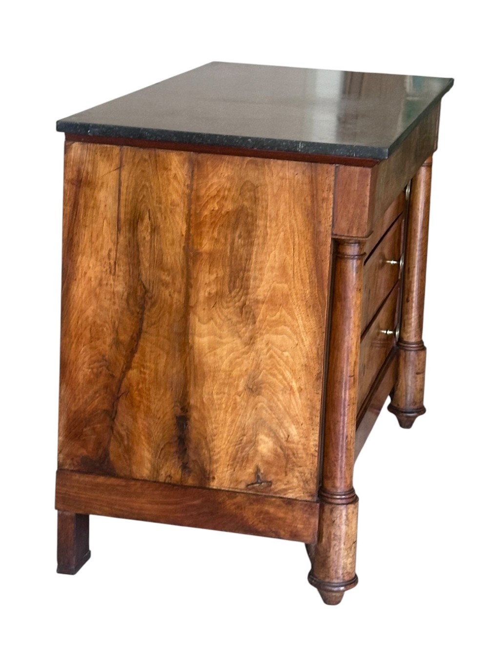 A 19th-century French Charles X walnut commode featuring three lower drawers with round metal pulls, flanked by architectural side columns and topped with a dark marble slab. View VIII