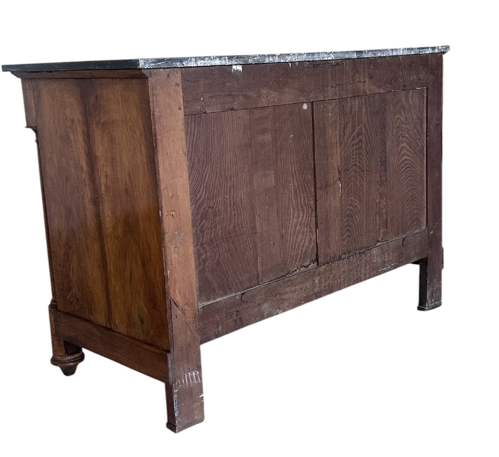 A 19th-century French Charles X walnut commode featuring three lower drawers with round metal pulls, flanked by architectural side columns and topped with a dark marble slab. View IX