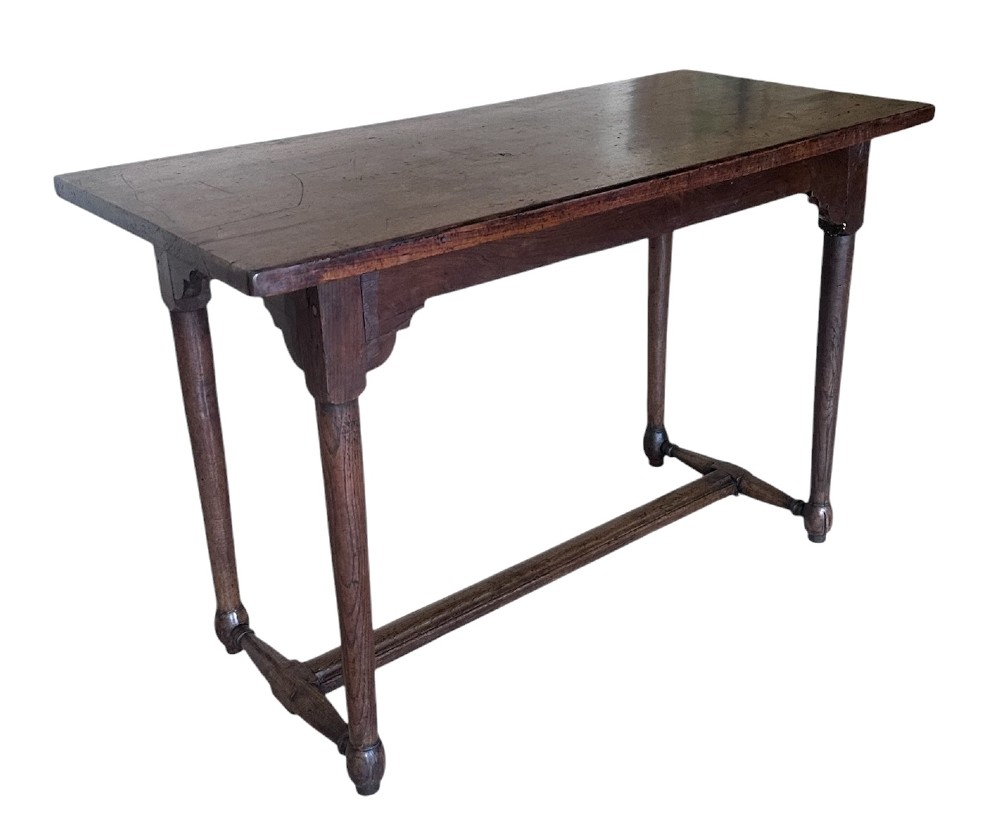 An 18th-century dark oak rectangular side table featuring turned legs connected by a low stretcher rail.