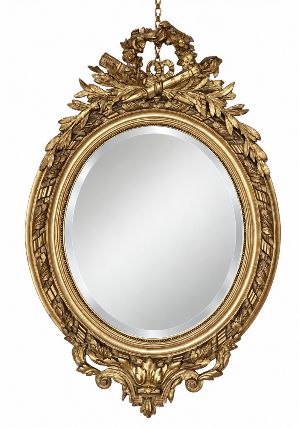 An oval giltwood wall mirror featuring an ornate carved crest with ribbon and foliage motifs above a moulded frame and decorative apron.