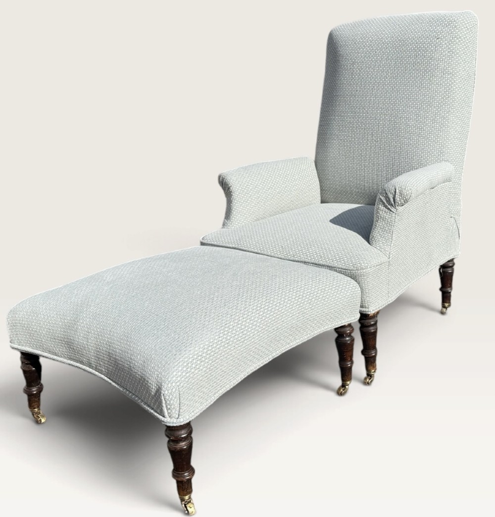 A 19th-century French reclining armchair and matching contoured footstool upholstered in pale blue woven fabric with dark turned wood legs on brass castors. View IX
