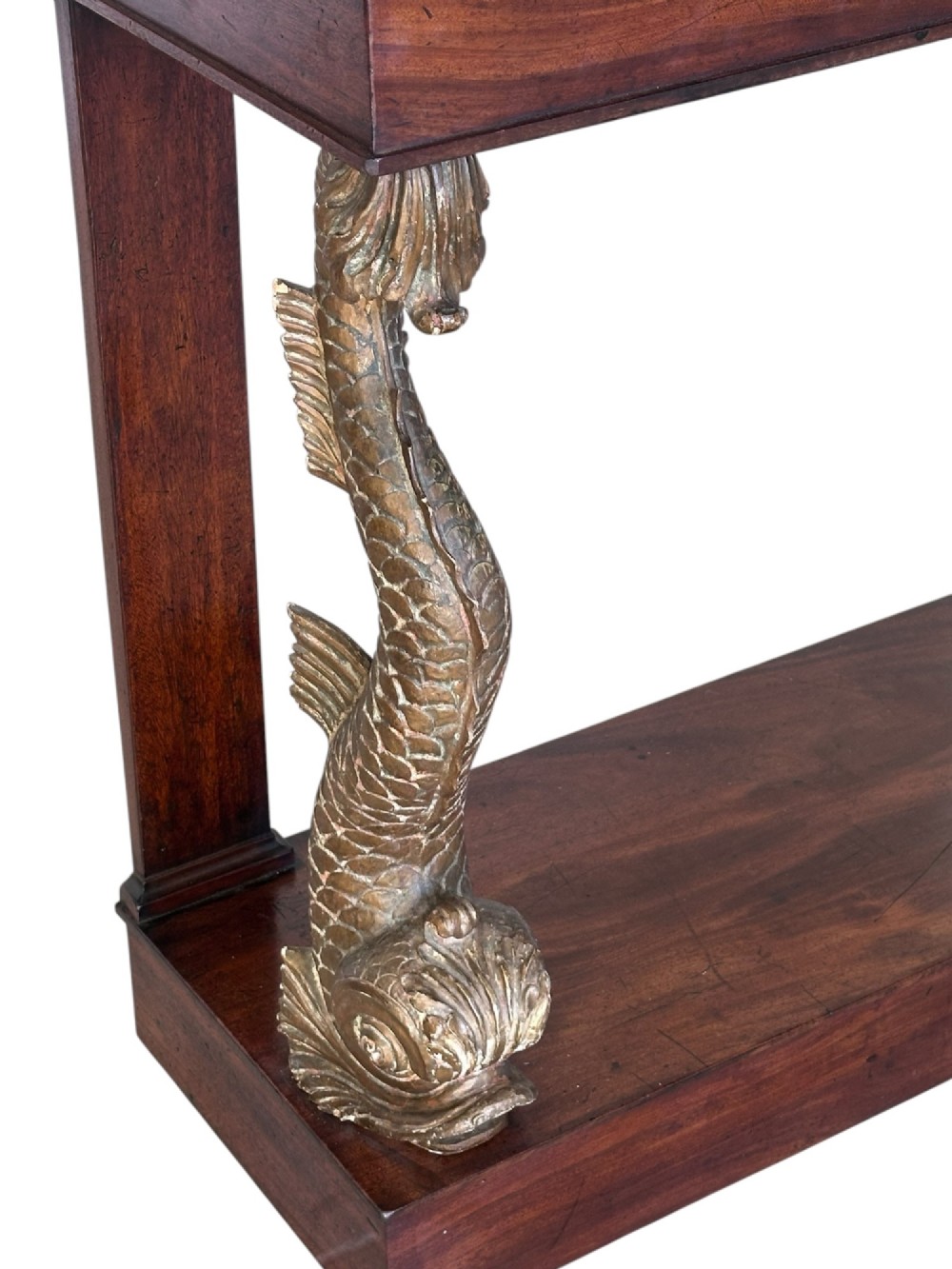 A 19th-century mahogany console table featuring a grey marble top, gilded carved dolphin front supports, and a low plinth base. View II