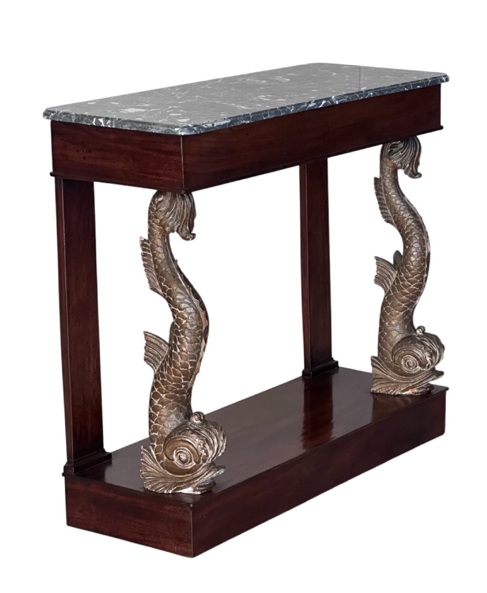 A 19th-century mahogany console table featuring a grey marble top, gilded carved dolphin front supports, and a low plinth base. View VI