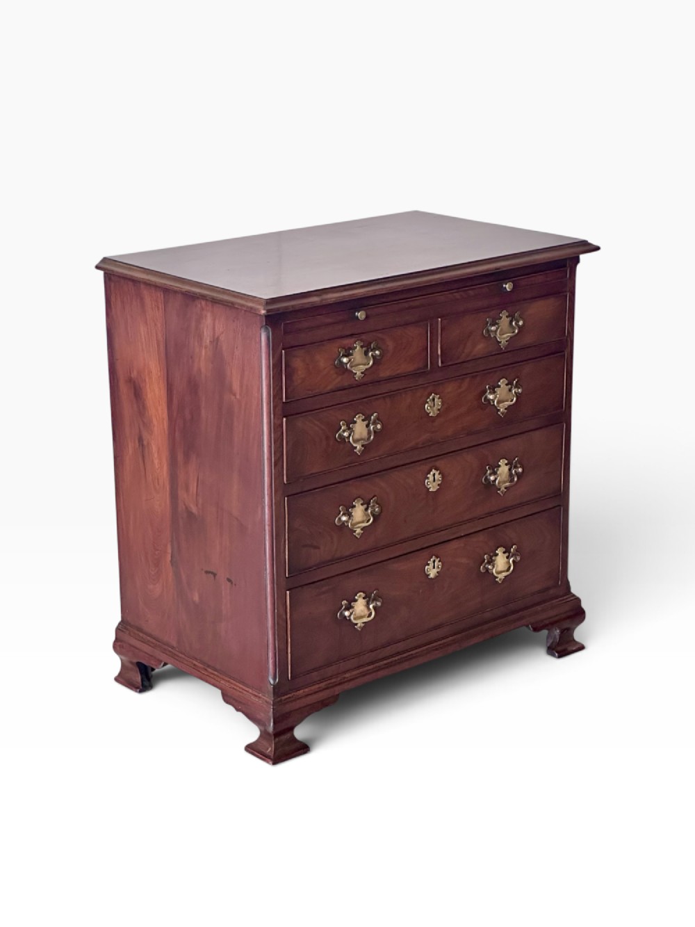 An 18th-century Georgian mahogany chest of drawers featuring a pull-out brushing slide, two short over three long drawers, brass handles, and bracket feet.
