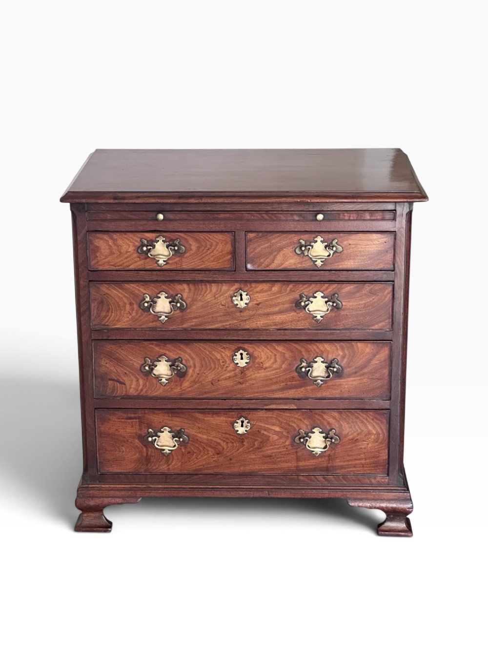 An 18th-century Georgian mahogany chest of drawers featuring a pull-out brushing slide, two short over three long drawers, brass handles, and bracket feet. View II
