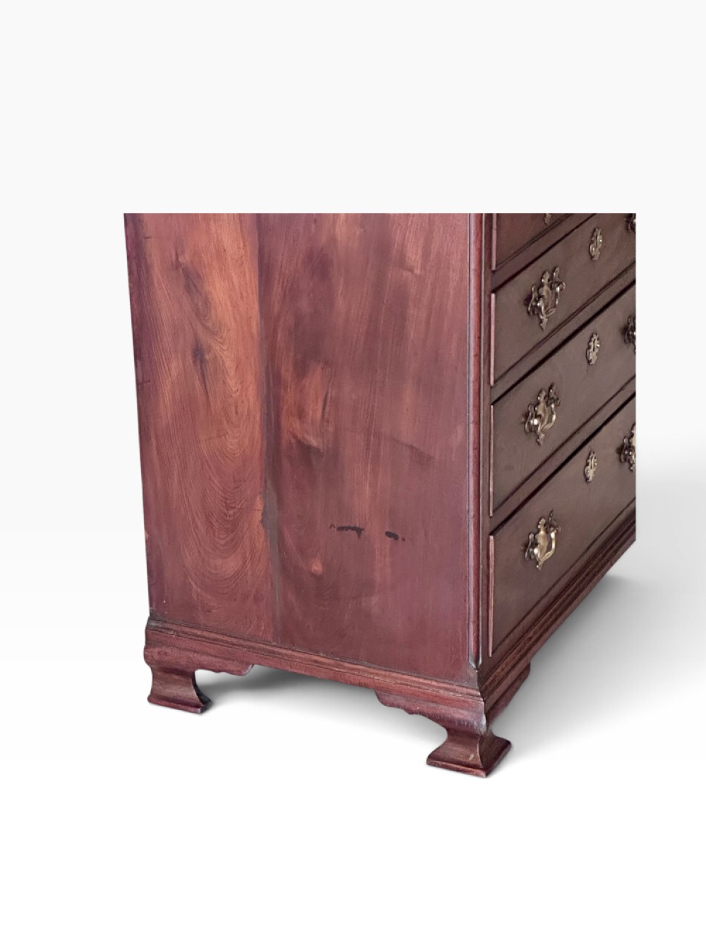 An 18th-century Georgian mahogany chest of drawers featuring a pull-out brushing slide, two short over three long drawers, brass handles, and bracket feet. View V