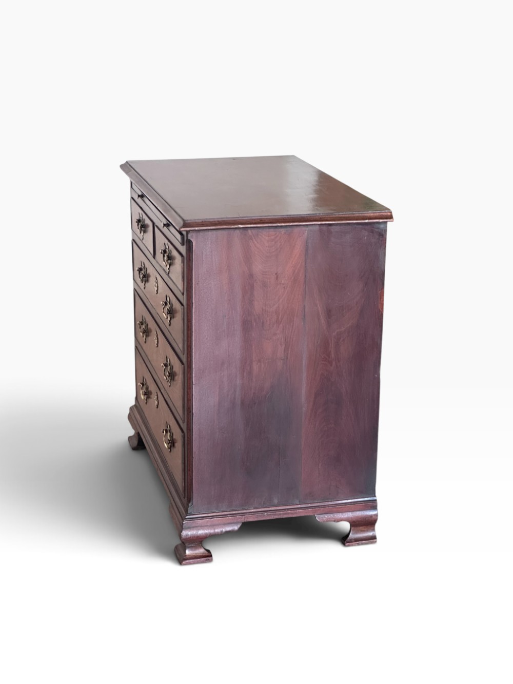 An 18th-century Georgian mahogany chest of drawers featuring a pull-out brushing slide, two short over three long drawers, brass handles, and bracket feet. View VII